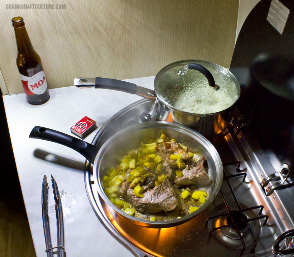Cooking local pork chops, apples, cauliflower, and Moa beer.