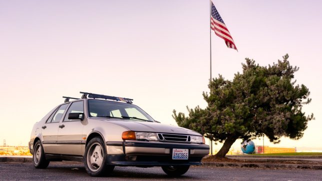 Saab 9000 with American flag at sunset.