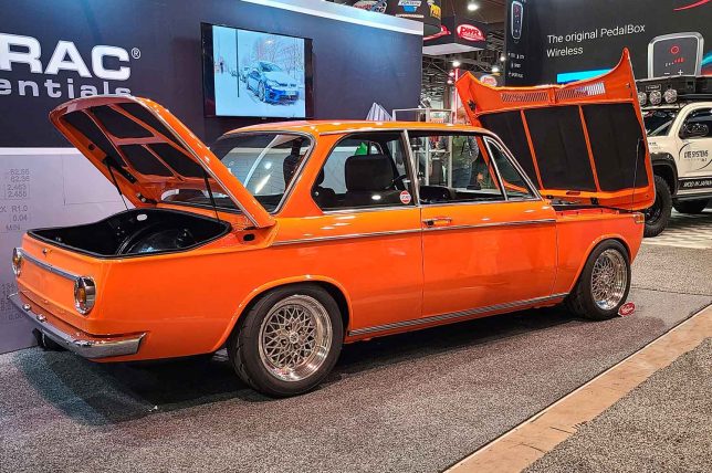 Orange BMW 2002 in the Wavetrac booth at the 2023 SEMA Show. 