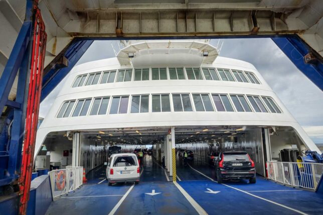 Driving onto a ferry boat with a blue platform. 