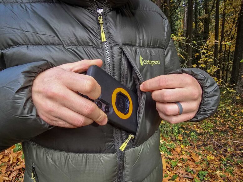 man wearing Cotopaxi Fuego Max down jacket, zippered chest pockets