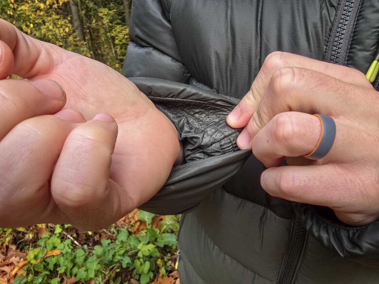 Man wearing Cotopaxi Fuego Max down jacket, inside sleeve detail