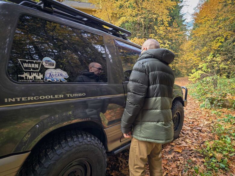 Man wearing Cotopaxi Fuego Max down jacket by vehicle