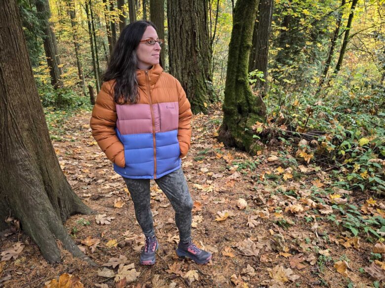 Woman wearing Cotopaxi Fuego Max down jacket in woods front side