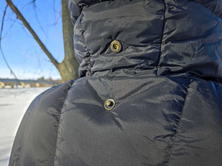 Woman wearing Fjallraven Expedition Lite Down Jacket in black, hood snap detail in back