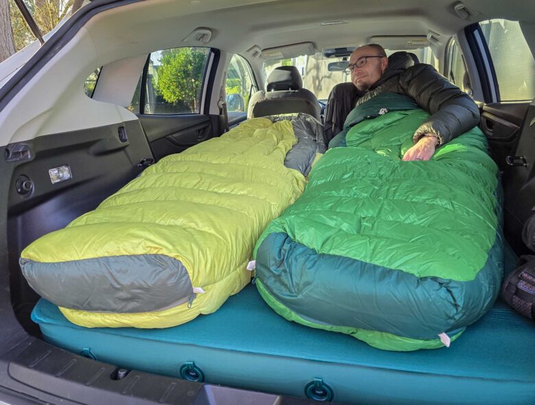 Man laying in one of the two Sea to Summit Ascent Down Sleeping Bags in car
