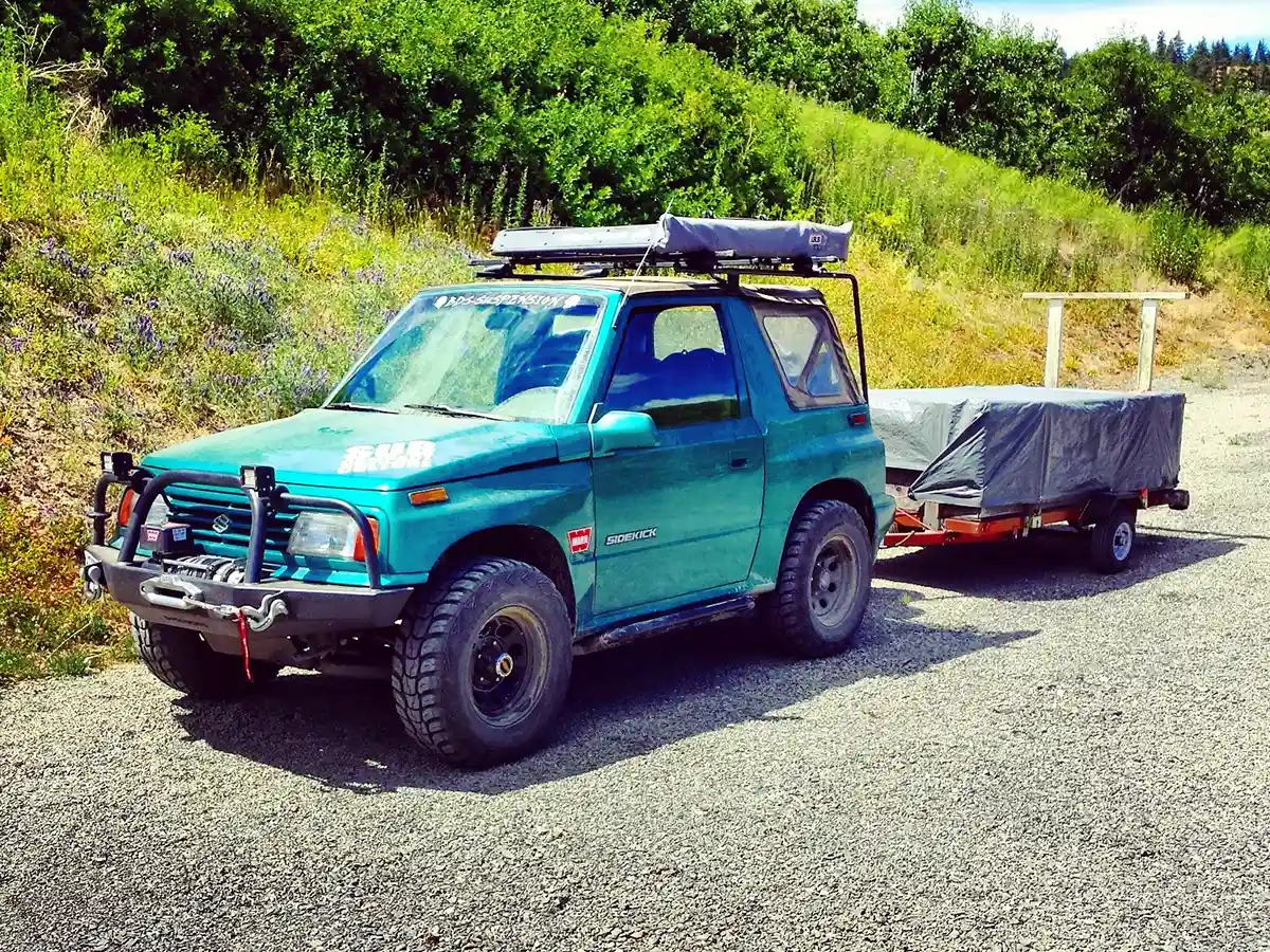 A Suzuki Sidekick pulling a small trailer