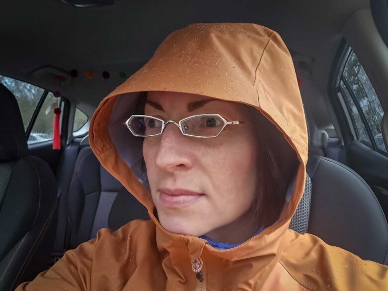 Cotopaxi Impermeo 3L Hooded Shell Jacket with hood up in car