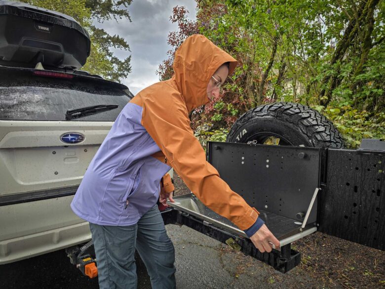Cotopaxi Impermeo 3L Hooded Shell Jacket zipped up, side view with hood up
