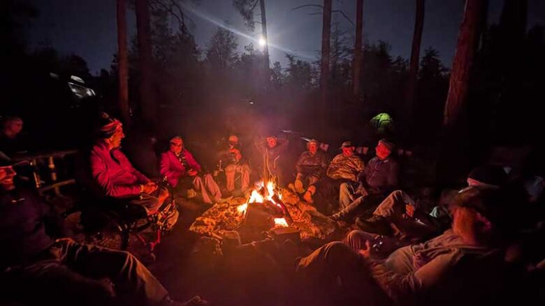 Fox Bravo Overland members and veterans around a campfire. 