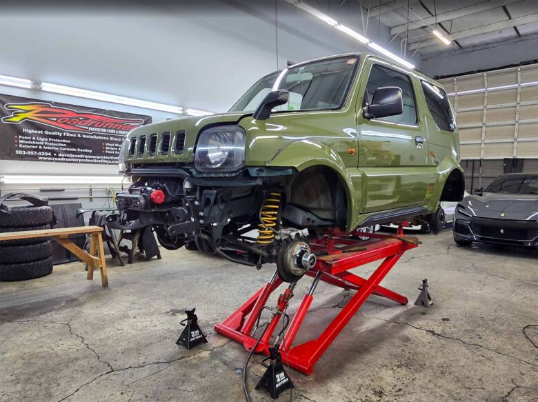 1998 Suzuki Jimny Wide on a hoist getting an XPEL wrap at Roadrunner Protective Films in Portland, Oregon.